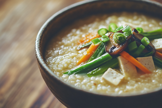 Eine Schale Frühlings-Congee mit grünem Spargel, Möhren, Shiitake, Tofu und Frühlingszwiebeln