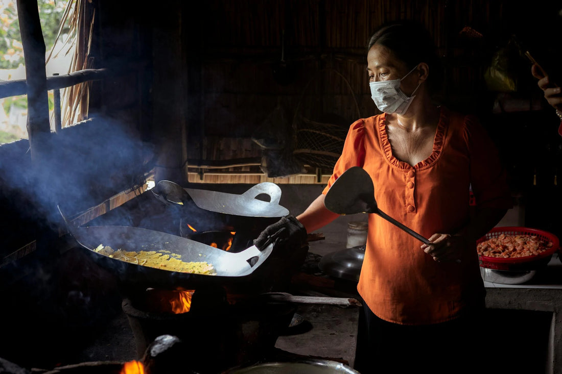 Frau mit Wok in vietnamesischer Küche